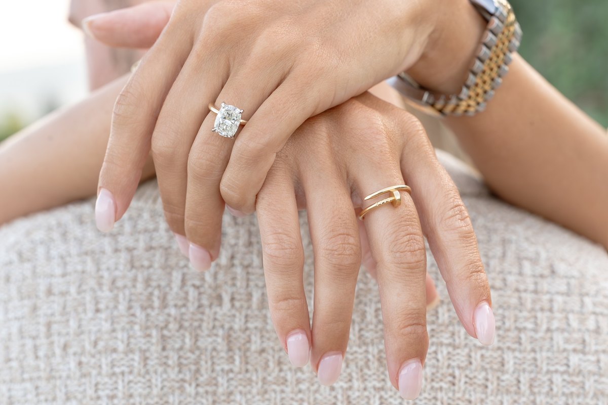 A close-up of Taylor and Jared's hands, showing her engagement ring and his ring.