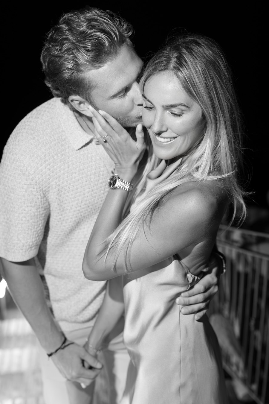 Black and white photo of Jared kissing Taylor on the cheek.