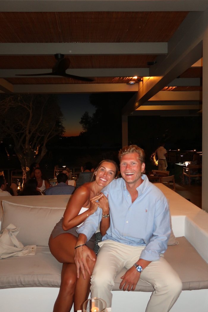 Taylor and Jared smiling together at an outdoor restaurant at night.